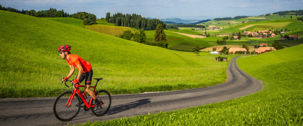 One male cyclist climbing out of Ami in the Emmental region of Kanton Bern, Switzerland
