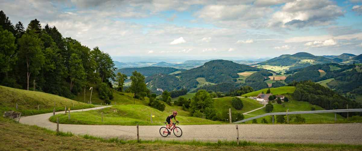 One male cyclist climbing Belchenpass (Jura mountains) in Kanton Baselland, Switzerland